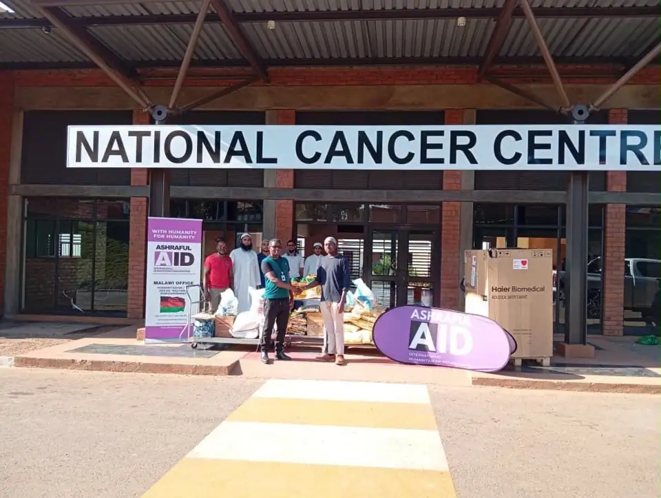 Ashraful Aid Malawi team handing over food at the National Cancer Centre entrance