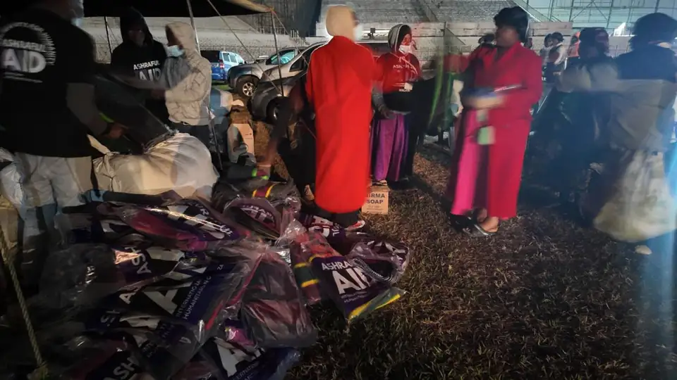 Volunteers handing out Ashraful Aid winter packs